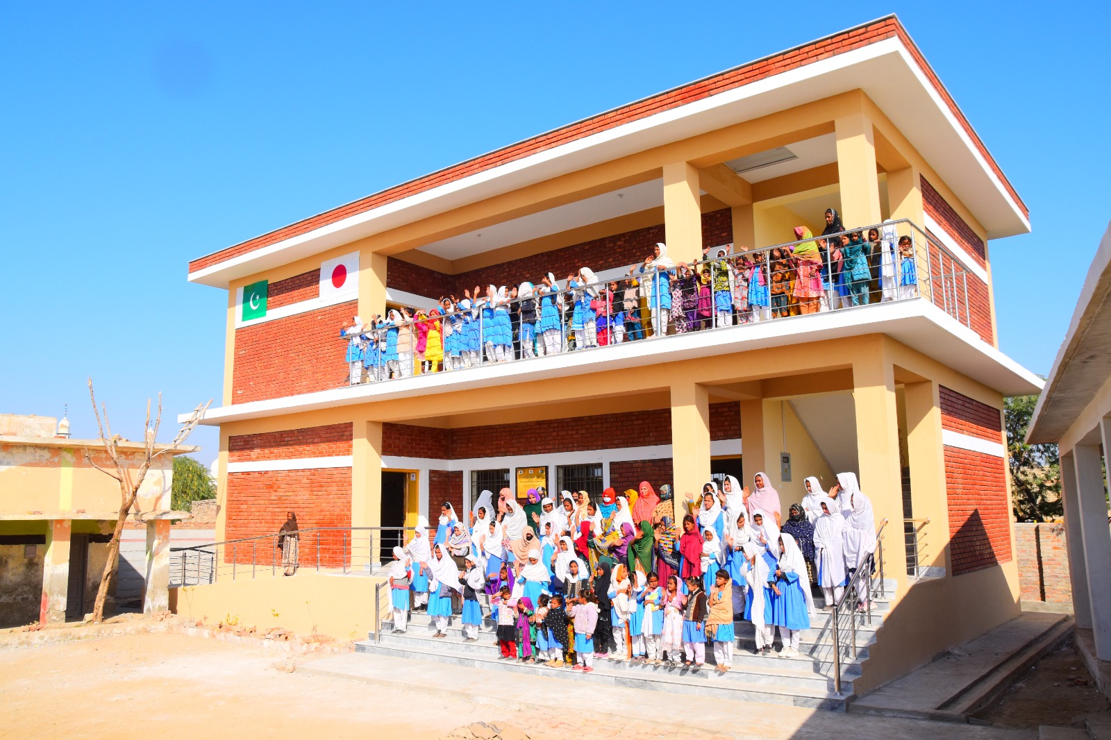 School — Students wave from the upper balcony of the new two-storey block.