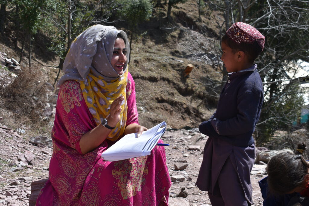 A KnK Japan volunteer speaking with a child during fieldwork
